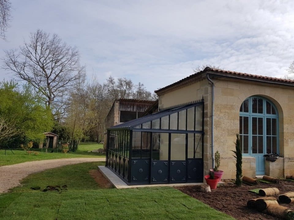 Pose d'une serre anglaise adossée avec soubassement à Castelnau de Medoc (33 - Gironde) vue 1